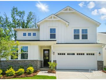 Stunning two-story home with white siding, stone accents, lush landscaping, and an attached two-car garage at 9846 Quercus Ln, Huntersville, NC 28078
