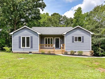 Charming blue home with a lovely wooden porch and well-manicured lawn, set against a backdrop of lush trees at 1117 Hidden Brook Ln, Clover, SC 29710