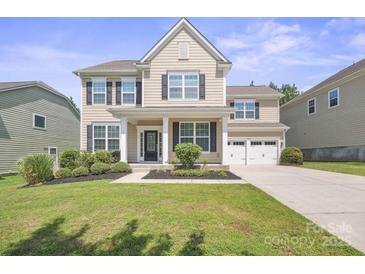 Charming two-story home with black shutters, lush landscaping and a two car garage at 128 Yellowbell Rd, Mooresville, NC 28117