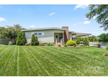 Charming single-story home featuring a well-manicured lawn, covered entry, and mature landscaping at 1627 33Rd Ne Ave, Hickory, NC 28601