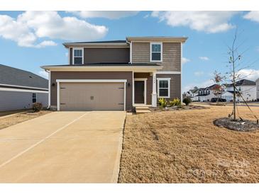Two-story home with a tan two-car garage, brown siding, and a well-manicured lawn at 2125 Rolling Hills Ct, Stanley, NC 28164