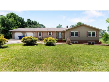 Charming home featuring manicured lawn, stone accents, red shutters, and an attached two-car garage at 5563 Grace Chapel Rd, Hickory, NC 28601