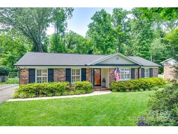 Charming brick home with a well-manicured lawn and lush landscaping at 7026 Tabor Ln, Charlotte, NC 28211