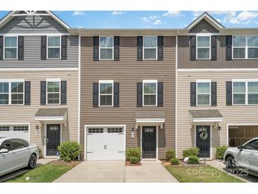 Townhome exterior with neutral siding, black shutters, a one-car garage, and well-maintained landscaping at 706 Dillon Way, Fort Mill, SC 29715