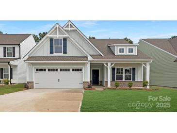 Inviting home featuring a two-car garage, charming porch, and well-maintained lawn at 170 Aspire Cir # 31, Wingate, NC 28174