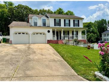 Charming two-story white home with a two-car garage, red brick accents, and a beautifully landscaped yard at 2008 Bantry Ln, Charlotte, NC 28262