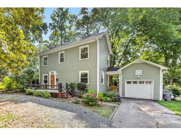 Charming two-story home boasts a quaint fenced yard, inviting entrance, and attached garage at 2034 Lanier Ave, Charlotte, NC 28205