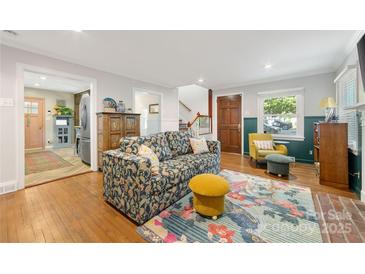 Bright living room featuring a floral sofa, hardwood floors, and stylish decor at 2034 Lanier Ave, Charlotte, NC 28205