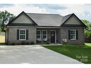 Charming brick home with black accents, cozy front porch and a long driveway at 604 E Ohio Ave, Bessemer City, NC 28016