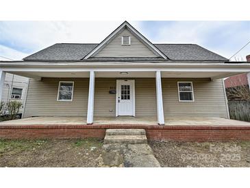 Charming home featuring a quaint front porch, neutral siding, and well-maintained landscaping at 613 E Liberty St, Salisbury, NC 28144