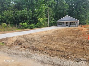 Charming single-story home with a long driveway and lush landscaping, perfect for serene living at 814 Generation Ln, Clover, SC 29710