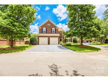 Beautiful brick home with well-manicured lawn, mature trees, and a two-car garage at 10418 Pullengreen Dr, Charlotte, NC 28277