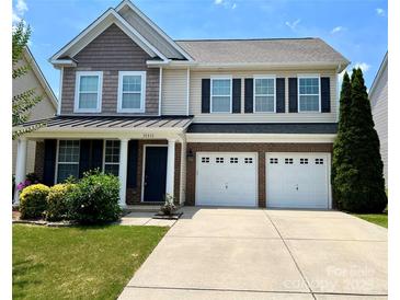 Charming two-story home with a well-manicured lawn and a two-car garage at 11511 Wilson Mill Ln, Pineville, NC 28134