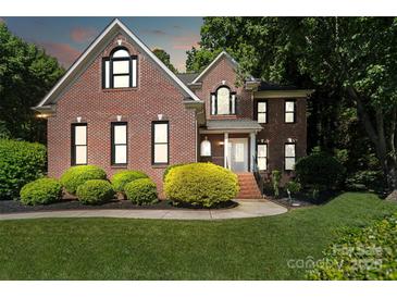 Charming two-story brick home with well-manicured lawn and mature landscaping at 121 Canterbury Xing, Fort Mill, SC 29708