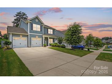 Charming two-story home with a two-car garage and a well-manicured lawn at dusk at 5069 Thomasville Dr, Belmont, NC 28012
