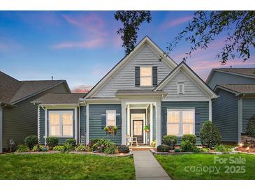Charming blue two-story home with a landscaped front yard, inviting entry, and lovely flower boxes beneath the windows at 1009 Hercules Dr, Indian Trail, NC 28079