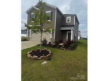 Charming two-story home features a landscaped front yard, attached two-car garage, and neutral color palette at 1022 Jeffery Dean Ct, Albemarle, NC 28001