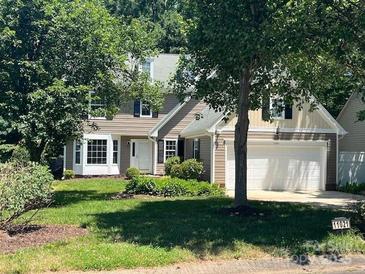 Charming two-story home with landscaped front yard and attached two-car garage at 11021 Scrimshaw Ln, Charlotte, NC 28215