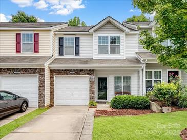 Charming townhome featuring stone accents, a single-car garage, and well-maintained landscaping at 13909 Singleleaf Ln, Charlotte, NC 28278