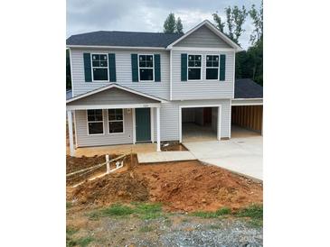 Charming two-story home with green shutters and a two-car garage in a suburban neighborhood at 323 Conner St, Lancaster, SC 29720