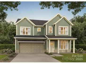 Charming two-story home featuring a two-car garage, covered porch, and a mix of siding and stone accents at 5116 Izzo Ln, Charlotte, NC 28214
