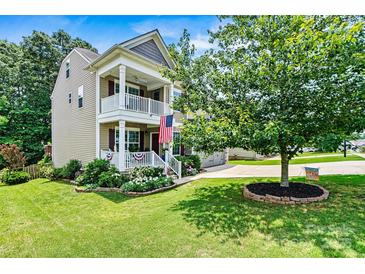Charming two-story home with a double stacked front porch, green lawn, and mature shade tree at 112 E Heart Pine Ln, Statesville, NC 28677