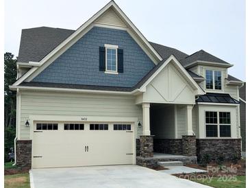 Charming two-story home featuring a stone-accented garage and a covered porch with stone pillar details at 16432 Cozy Cove Rd, Charlotte, NC 28278