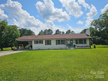 Charming one-story home with a white brick exterior and well-manicured front lawn at 3546 Kershaw Camden Hwy, Lancaster, SC 29720