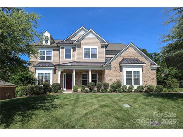 Inviting two-story home featuring a manicured lawn, brick accents, and a covered front porch with columns at 398 Hampton Trail Dr # 97, Fort Mill, SC 29708