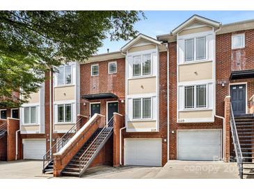 Brick townhome exterior with stairs leading to the front door and attached garages at 1125 Kurt Ct, Charlotte, NC 28209