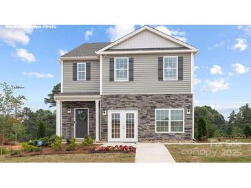 Charming two-story home with stone accents, gray siding, and a well-manicured front yard at 12020 Zazu Way, Charlotte, NC 28215