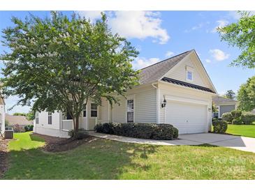 Charming home featuring a two-car garage, well-manicured lawn, and a mature, flowering tree in the front yard at 1471 River Bend Blvd, Indian Land, SC 29707