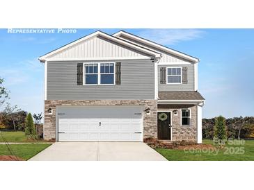 Charming two-story home with stone accents, a white garage door, and well-maintained landscaping at 219 Parker Claire Ln, Kings Mountain, NC 28086