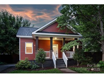 Charming red home with a welcoming front porch and landscaped garden at sunset at 3519 Card St, Charlotte, NC 28205