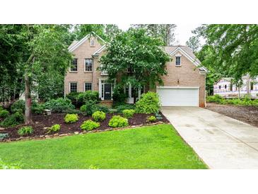 Brick two-story home with mature landscaping, green lawn, and attached two-car garage at 4007 Lake Shore S Rd, Denver, NC 28037