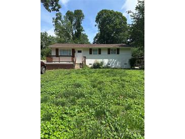 Charming single-story home with a lovely front porch and a partially-covered front yard at 5200 Queen Anne Rd, Charlotte, NC 28217