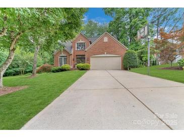 Traditional brick home with a well-manicured front yard, long driveway, and a basketball hoop, perfect for outdoor activities at 9040 Scottsboro Dr, Huntersville, NC 28078