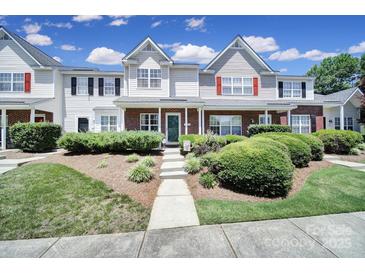 Charming townhome featuring a brick facade, manicured landscaping, and a welcoming front porch at 10078 Pergola View Ct, Charlotte, NC 28213