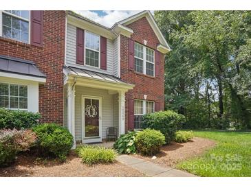 Charming townhome entrance with brick facade, decorative door, and manicured landscaping at 12342 Swan Wings Pl, Huntersville, NC 28078