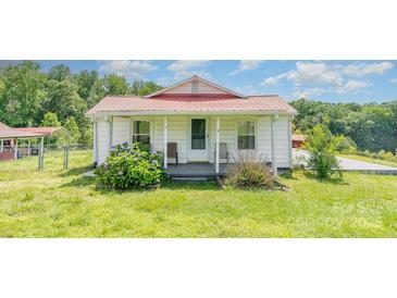 Charming single-story home with white siding, red metal roof, and cozy front porch at 439 Neisler Rd, Concord, NC 28025