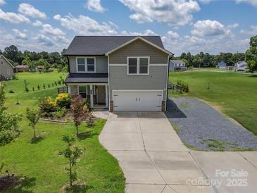 Charming two-story home featuring a two-car garage and a well-manicured front yard at 556 Big Lick Rd, Stanfield, NC 28163