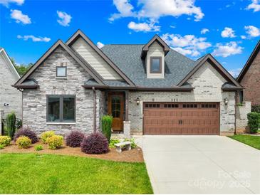 Beautifully landscaped, two-story home featuring a stone facade, brick accents, and a two-car garage at 6107 Gold Springs Way, Denver, NC 28037