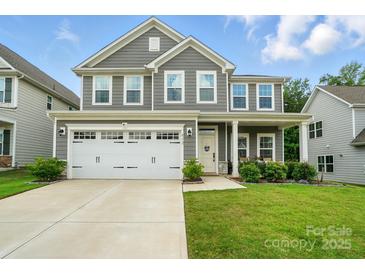 Charming two-story home with a two-car garage, landscaped yard, and inviting front porch at 812 Dogwood Creek Ln, Indian Trail, NC 28079