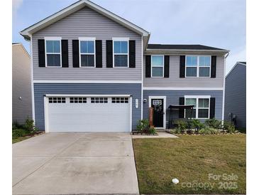 Charming two-story home with a two car garage, black shutters, and a welcoming front porch at 1047 Campbell Chase Sw Ln, Concord, NC 28025