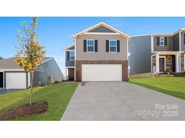 Charming two-story home featuring a brick and siding exterior, attached garage, and well-maintained lawn at 1450 Mammoth Rd, Hickory, NC 28602
