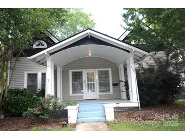 Charming home featuring a covered front porch with white pillars and blue painted steps at 510 5Th St, Spencer, NC 28159