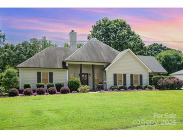 Charming single-story home with lush landscaping and a welcoming front porch at 5701 Cedar Hill Dr, Monroe, NC 28110