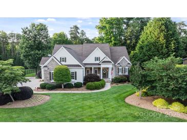Charming home with a well-manicured lawn, stone accents, and mature trees at 132 Ragsdale Trl, Mooresville, NC 28117