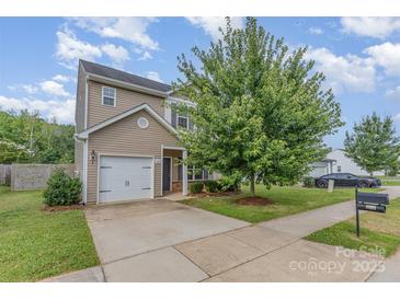 Charming two-story home with landscaped front yard, paved driveway, and attached one car garage at 1404 Waylon Ave, Gastonia, NC 28054