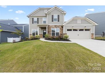 Charming two-story home featuring stone accents, a well-manicured lawn, and attached two car garage at 14116 Glaswick Dr, Charlotte, NC 28278